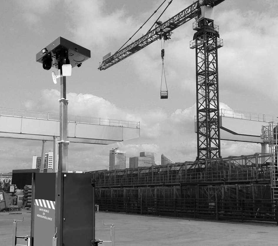 Detection head of an OMNIGARD tower standing in front of a crane, on a working construction site